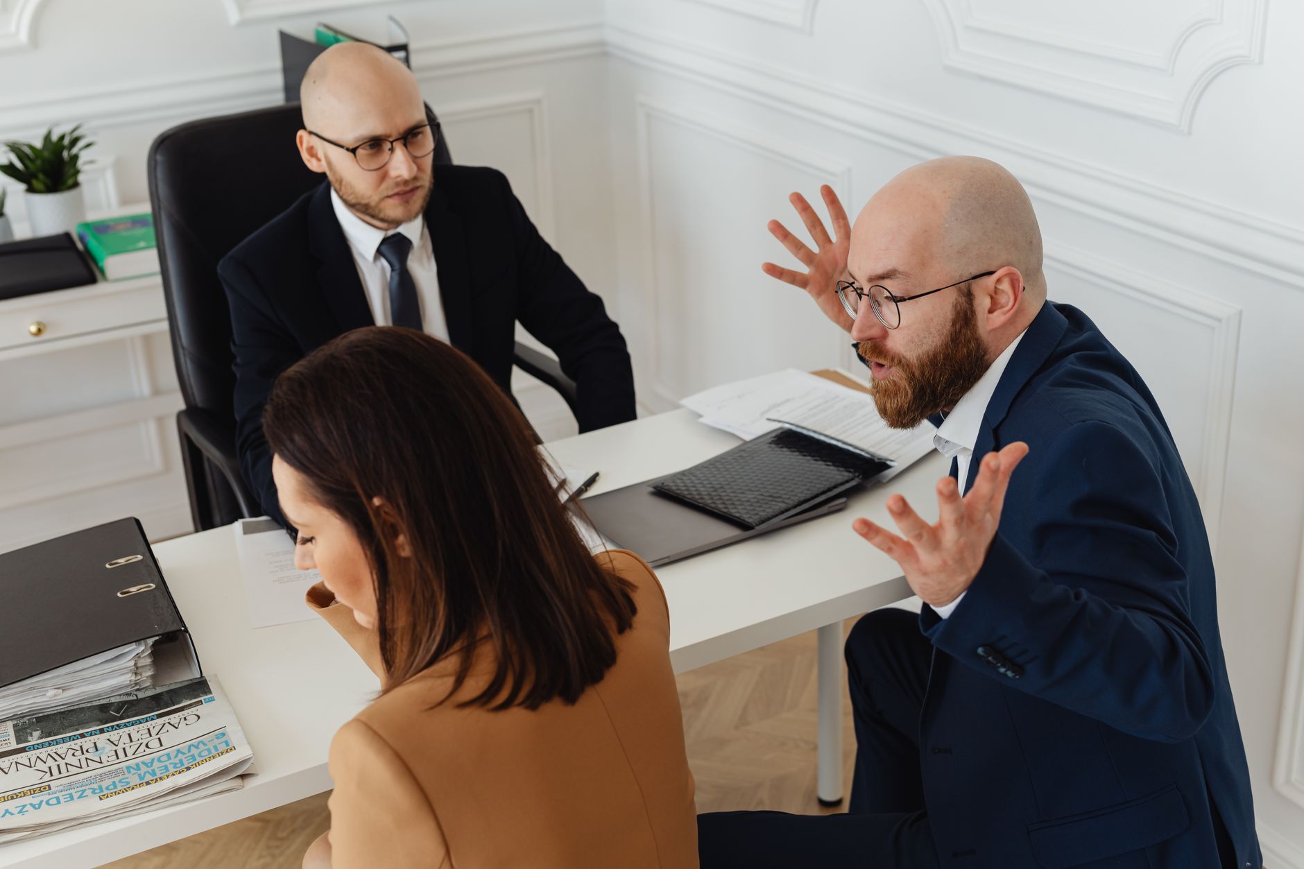Three colleagues in a heated discussion during an office meeting.